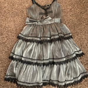 Silver, layered dress with black lace trim and leather straps.